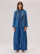 Pantalon de jean ancho, de corte holgado y fluido desde la cadera hasta el tobillo, con costuras verticales decorativas en el frente.