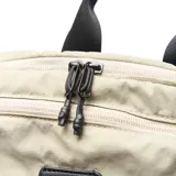 Mochila gris de tela con doble cierre, forro interior textil, múltiples bolsillos exteriores y bolsillo interno con cierre.