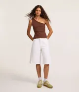 Bermuda jorts de sarga blanca, con cinco bolsillos, trabillas en la cintura y cierre frontal de cremallera y botón.