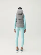 Chaleco acolchado reversible con capucha, cierre frontal de cremallera y bolsillos laterales. Diseño cortavientos y funcional con relleno vegano.