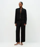 Pantalón de sastrería color negro con corte recto y estructura firme. Presenta cintura con pasadores, cierre frontal y bolsillos traseros embutidos. Incluye un cinturón fino con hebilla metálica.