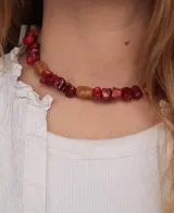 Gargantilla corta de cuentas de madera en tonos rojo y tostado, con diseño artesanal.