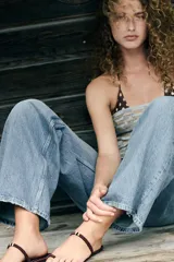 Sandalia plana con tira para el dedo y tira en el empeine con detalle de abalorios. Suela con pespuntes a contraste de color y acabado en punta redonda.