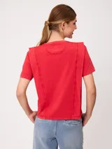 Remera de manga corta color rojo, de corte holgado, con cuello redondo y costuras decorativas frontales.