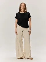 Remera negra de punto fino, con mangas cortas, cuello redondo y corte relajado. Cuenta con costuras verticales decorativas en el frente.