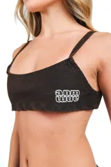 Top tipo bralette de denim lavado color marrón, con breteles finos, elástico en la espalda y bordado frontal con logo.