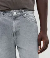 Pantalón de jean con corte recto y tiro medio, diseño clásico de cinco bolsillos con cierre de botón y cremallera. Confeccionado en algodón resistente.