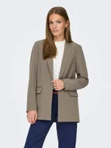 Blazer largo de corte holgado con solapas clásicas y bolsillos delanteros con solapa. Confeccionado en una mezcla de poliéster reciclado y elastano.