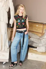 Jeans de corte barrel color celeste, confeccionados en 100% algodón, con diseño de perneras curvas y costuras decorativas en las rodillas.