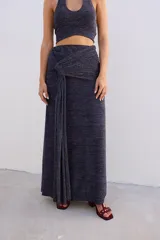 Falda larga de tejido brillante color azul con detalle de nudo en la cintura.