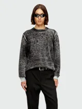 Buzo de punto con textura jaspeada en tonos gris y negro, cuello redondo y mangas largas con puños en contraste. Presenta costuras expuestas en los hombros.