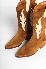 Bota estilo texana de gamuza color marrón, con diseño de apliques en forma de llamas en color crema y taco de madera.