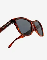 Lentes de sol Hawkers modelo One con armazón de acetato en estampado carey y cristales polarizados oscuros.