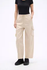 Pantalon cargo de tiro bajo en color beige, con bolsillos laterales amplios y cintura ajustable con cordón.