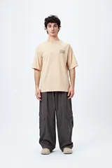 Remera blanca de corte amplio con mangas cortas y estampado con la frase "Unlearn" en el frente y gráfico en la espalda.