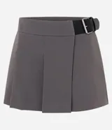 Short pollera sastre de color marrón oscuro, con diseño de plegado delantero que simula una pollera, cintura estructurada y cinturón lateral integrado con hebilla metálica.