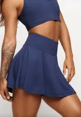 Pollera short deportiva color verde esmeralda, con short interno con bolsillos laterales.