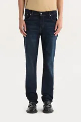 Pantalón de jean azul oscuro, corte slim, tiro bajo y confección stretch.