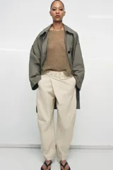Trench oversize de Zara Woman Collection, confeccionado en hilatura de algodón. Presenta cuello solapa, manga larga, bolsillos delanteros y cierre frontal con botones ocultos bajo solapa.