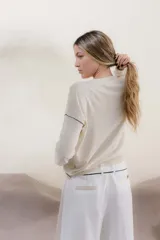 Sweater color crema con rayas horizontales y mangas largas.