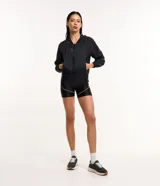 Campera rompevientos deportiva blanca, confeccionada en poliamida, con capucha, cierre delantero en cremallera, tirador gomoso y puños ajustados.