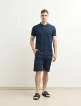 Remera polo azul marino con estampado de pequeños puntos blancos, cuello clásico con tres botones y mangas cortas.