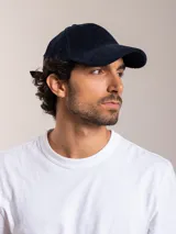 Gorra de pana color camel con visera curva y logo bordado en el lateral.