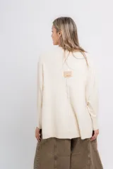 Sweater color crudo de punto, con cuello redondo y corte suelto.