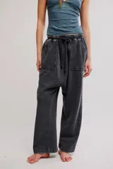 Pantalón harem amplio color gris oscuro con efecto lavado, tiro caído, cintura elástica con cordón de ajuste y grandes bolsillos parche en la parte delantera.