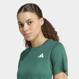 Remera deportiva Adidas verde con cuello redondo y el logo de la marca estampado en blanco en el pecho.