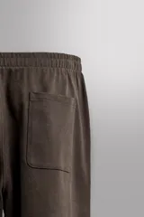 Pantalón jogger de corte relajado confeccionado en tejido compacto de algodón. Presenta cintura elástica con cordón interior, bolsillos frontales en la cadera y un bolsillo trasero de plastrón.