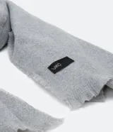 Bufanda larga de tejido suave, color negro, con bordes deshilachados.