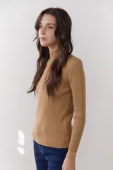 Polera de tejido morley color azul, con cuello alto y mangas largas, de corte ajustado al cuerpo.