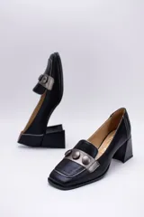 Zapato de cuero verde con aplique de cuero azul y botones forrados.