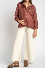 Pantalón de jean color beige, de corte wide leg con botamanga desflecada y tiro medio, diseñado especialmente para maternidad.