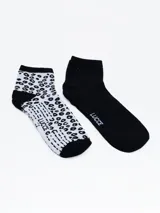 Pack de dos pares de medias cortas, un par negro liso con logo lateral y un par blanco con estampado animal print en negro.