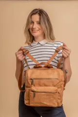 Mochila mediana de símil cuero color tostado, con diseño de textura arrugada, dos compartimentos frontales con cierre y correas ajustables de cinta al tono.