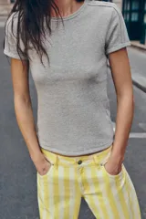 Camiseta de manga corta gris melange con cuello redondo y costuras decorativas visibles en los hombros.