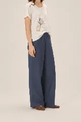Pantalón de lino azul marino, de corte recto y holgado, con cintura elástica.
