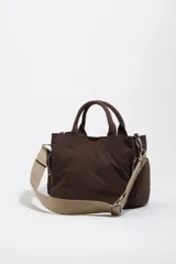 Bolso bandolera Pocket Bimba Y Lola de tamaño mediano, color tostado, confeccionado en nylon con estructura blanda, doble asa de mano y correa de tejido. Incluye un bolsillo exterior frontal con cierre y el logo metálico de la marca.