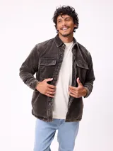 Sobrecamisa de pana color beige, con cierre frontal de botones a presión, dos bolsillos frontales con solapa y bolsillos laterales. Presenta cuello clásico y diseño acolchado con forro interior.