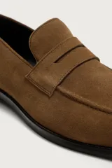 Mocasín casual fabricado en piel con acabado de serraje, con detalle de bordón y antifaz en el empeine, horma redonda y suela a contraste.