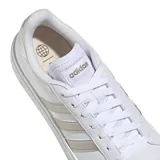 Championes urbanos Adidas modelo Grand Court Base 2.0, color blanco con las icónicas tres franjas laterales en tono gris metalizado. Presentan un diseño inspirado en los años 70 con suela tipo cupsole de caucho y cierre mediante cordones.