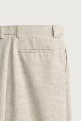 Pantalón relaxed fit de color blanco off-white, confeccionado en tejido con lino. Cuenta con pliegues frontales en la cintura, bolsillos delanteros y cierre frontal con cremallera y botón.