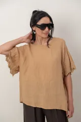 Blusa de lino color tostado, de corte holgado y manga corta con inserción de puntilla bordada.