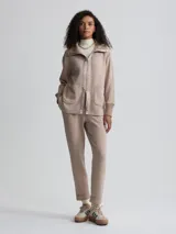 Campera color beige de corte holgado, con cierre frontal, cuello alto y bolsillos de parche grandes.