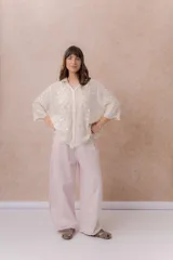 Pantalón de denim liviano color beige, de calce amplio y relajado con pierna recta. Cuenta con cintura elastizada, cordón regulable, bolsillos laterales y costuras delanteras verticales que estilizan la silueta.
