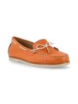 Mocasín de cuero naranja con textura granulada, detalle de lazo frontal blanco con punteras metálicas y costuras a la vista. Cuenta con suela plana de goma en tono crema.