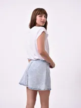 Minifalda de denim en color celeste con efecto acid wash y costuras pespunteadas en contraste.