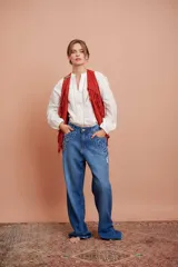 Blusa blanca de manga larga con cuello mao, abertura frontal con detalle de vainica y diseño amplio.